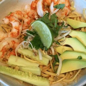 An Asian noodle bowl recipe featuring succulent shrimp combined with creamy avocado and zesty lime.