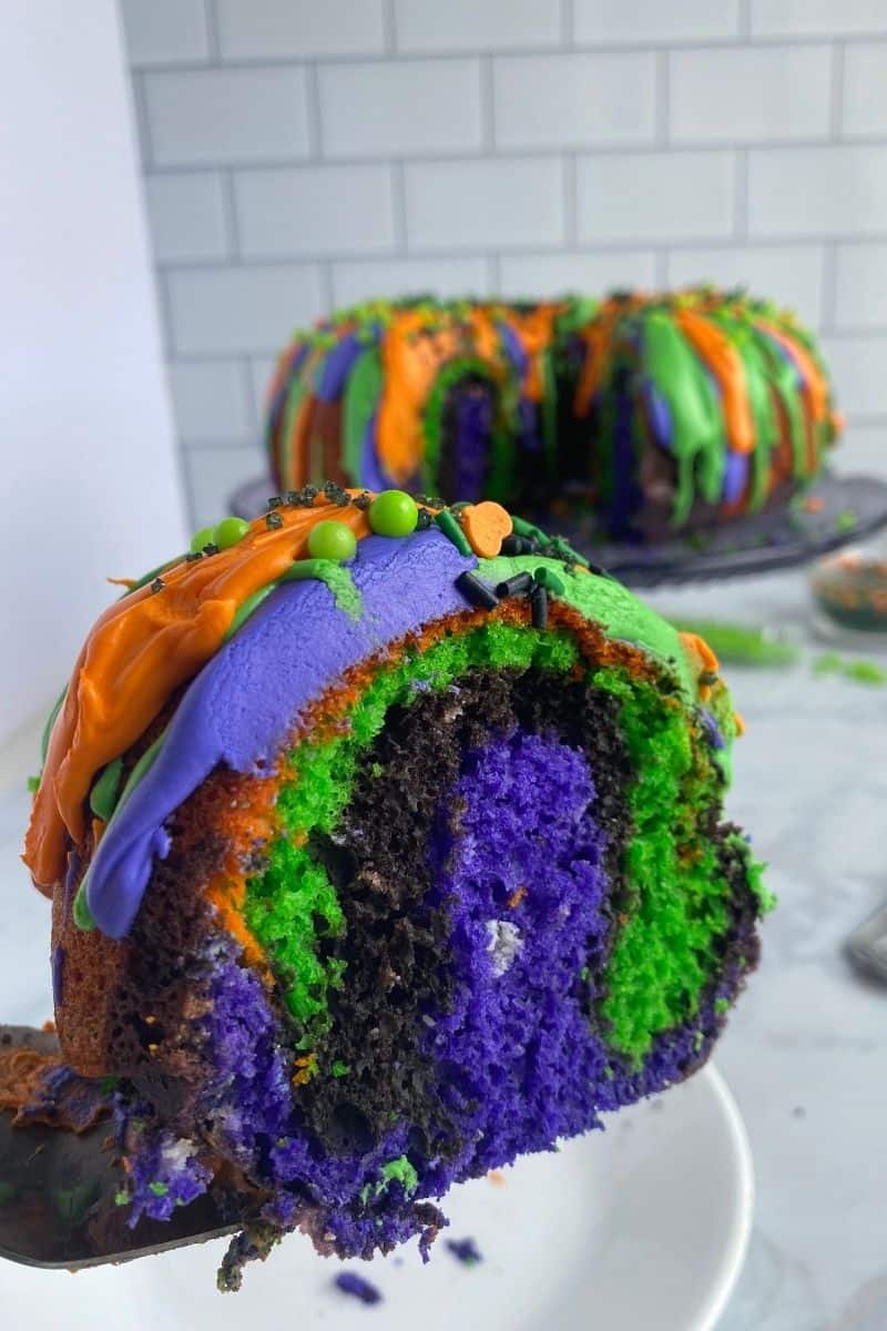 slice of bundt cake showing purple, black, orange, and green swirls