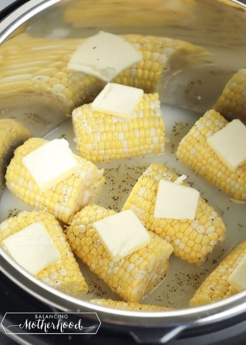 corn on the cob pieces with pats of butter on top in instant pot