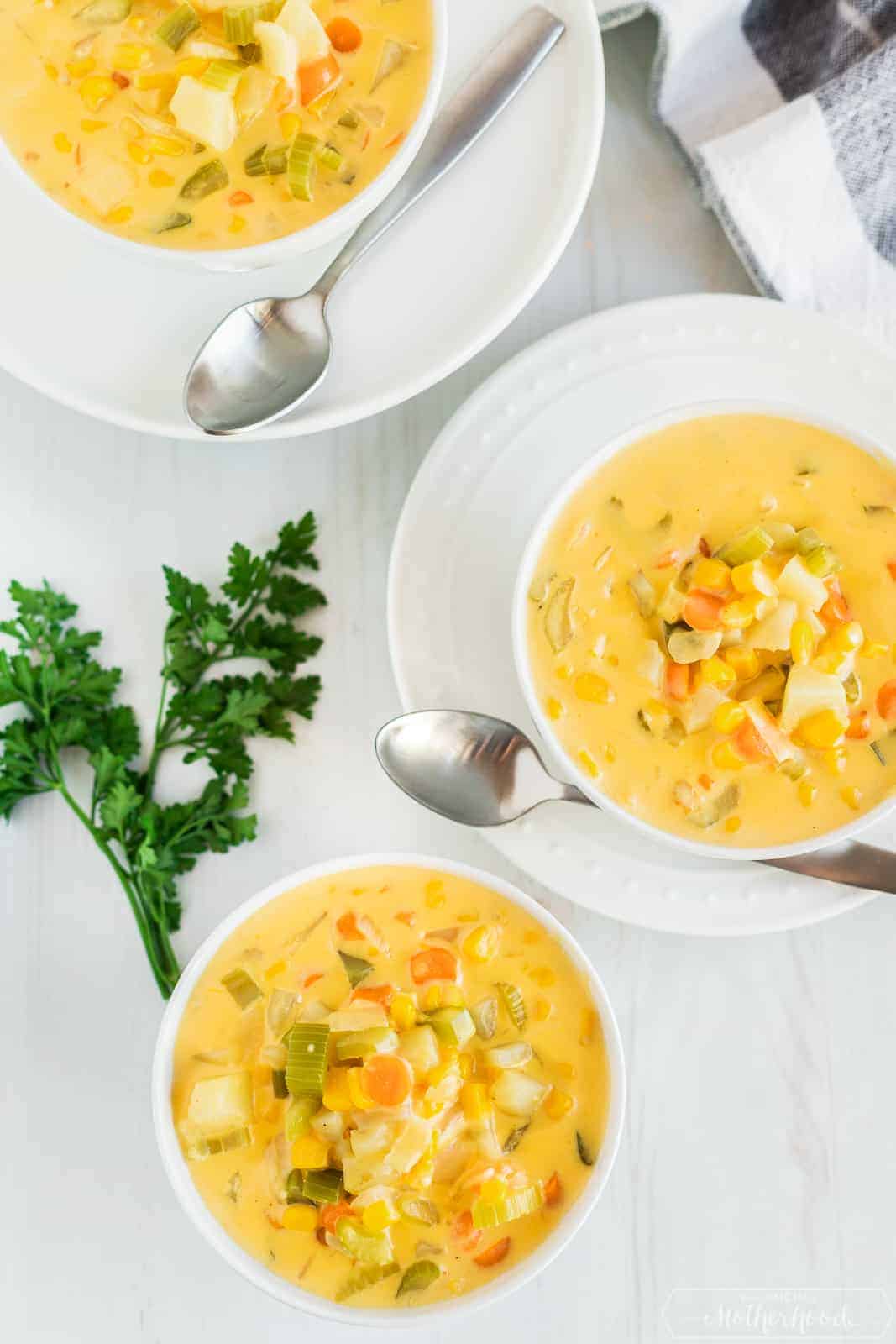 three bowls of delicious corn chowder with a sprig of parsley