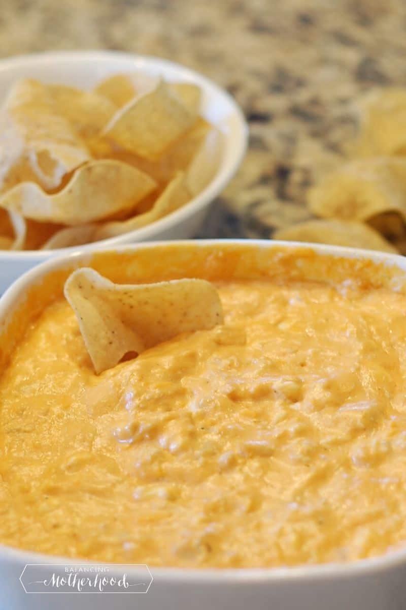 buffalo chicken cheese dip in white bowl with tostido chip