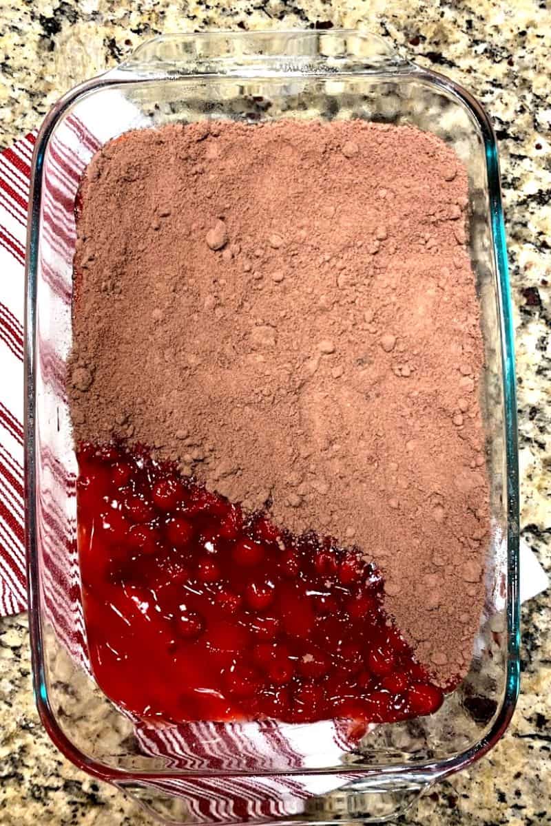 cherry pie filling and chocolate cake mix in glass baking dish