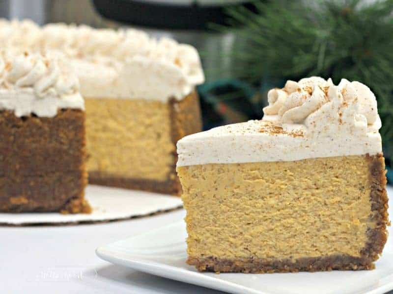 slice of pumpkin cheesecake with whole pumpkin cheesecake in background