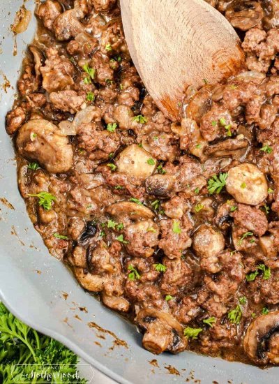 ground beef and seasonings in pan with wooden spoon