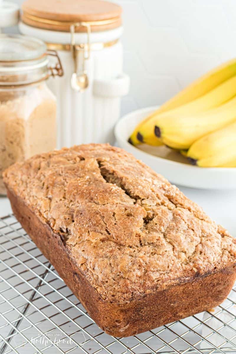 whole loaf of banana bread out of the pan with bananas in background