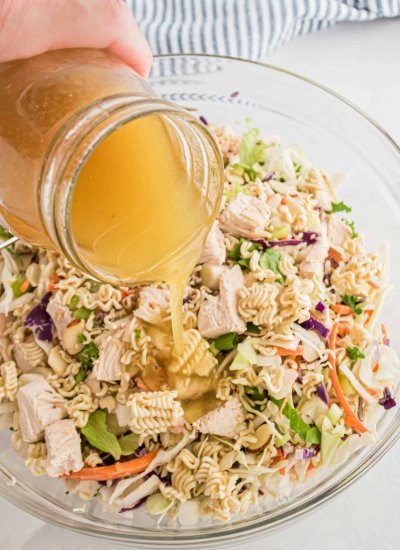 pouring dressing on Chinese chicken salad