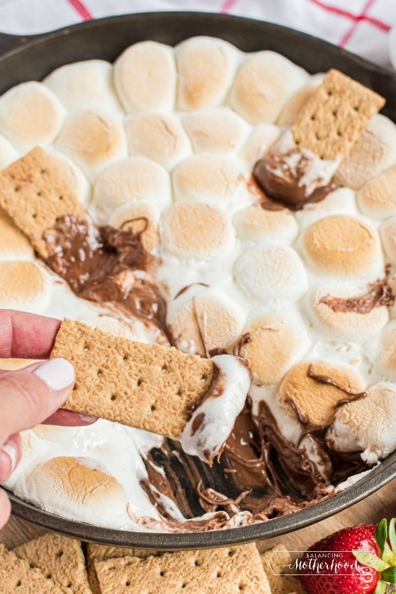 pan with smores dip and graham cracker dipping in it