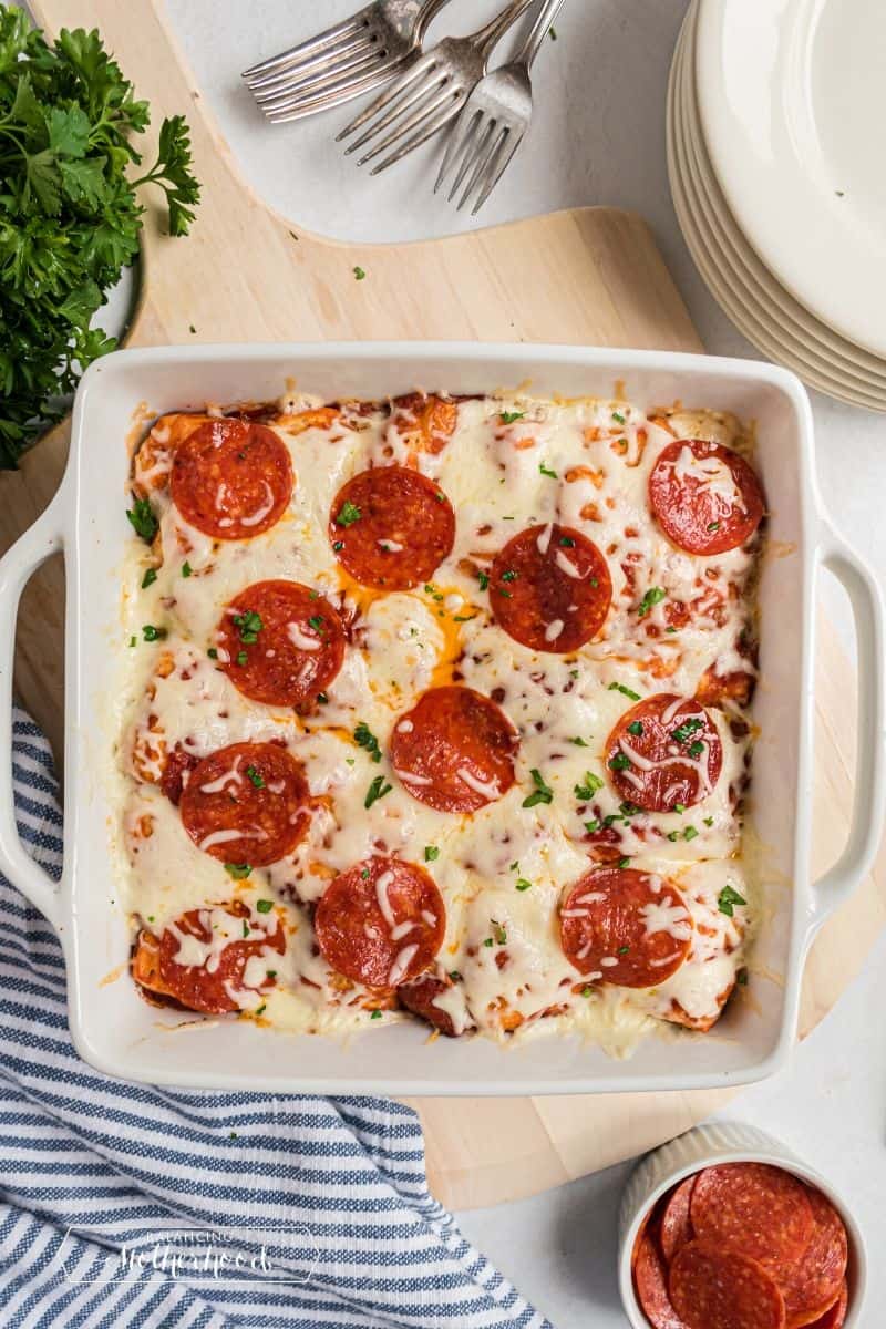 White casserole dish with bubble pizza fresh out of the oven.