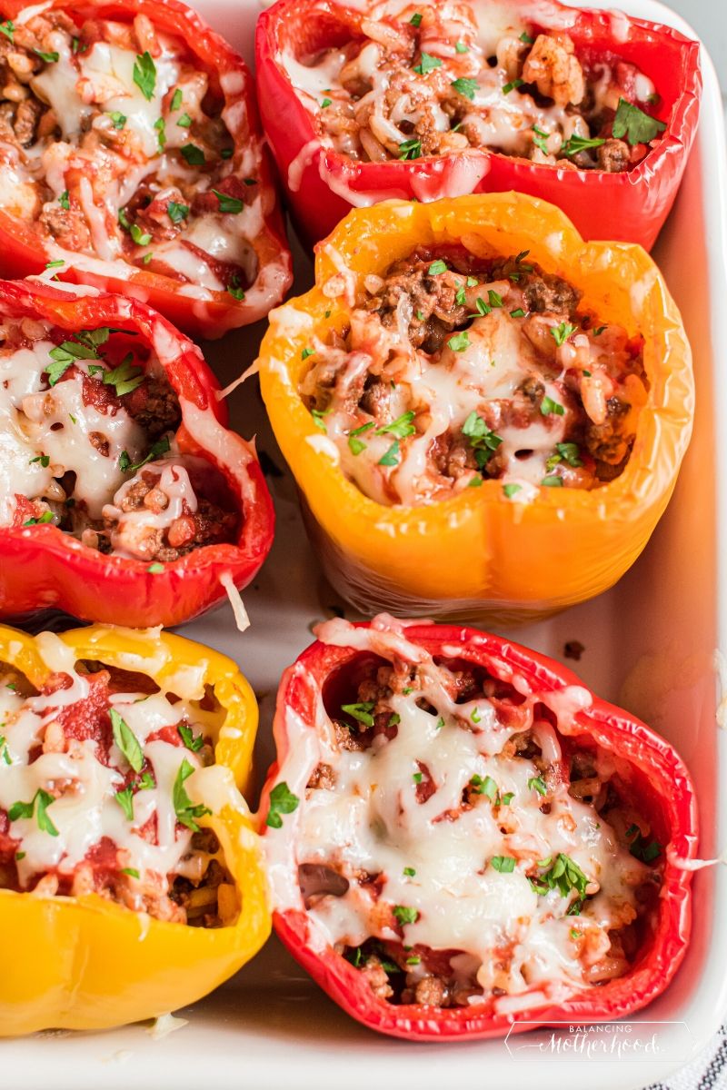 red and yellow peppers in casserole dish, stuffed with ground beef and cheese mixture
