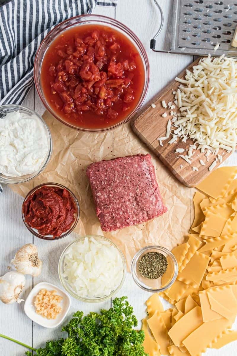 skillet lasagna ingredients: diced tomatoes, mozzarella cheese, ricotta cheese, ground beef, tomato paste, lasagna noodles and seasonings