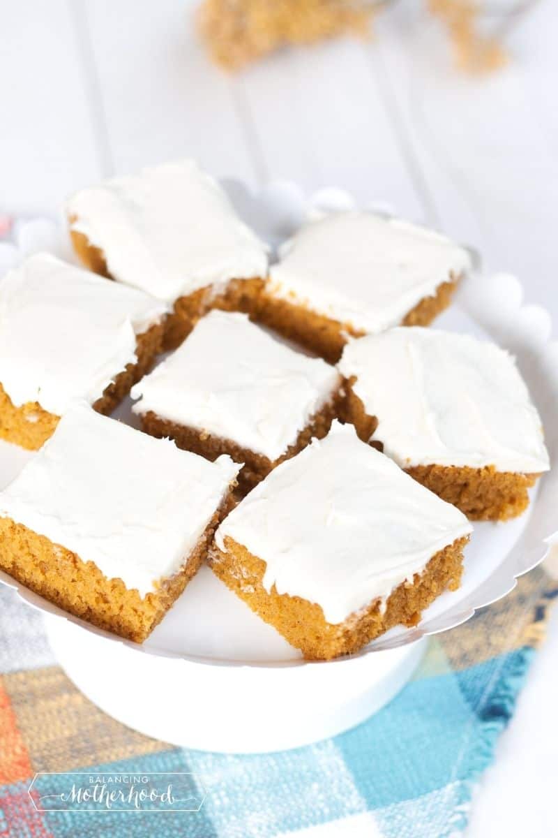 orange pumpkin squares with cream cheese frosting on cake tray