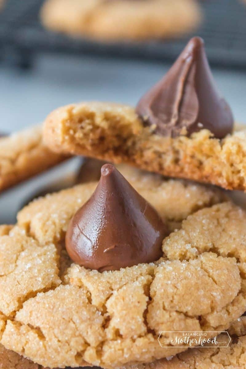 stack of peanut butter blossom cookies with a bite out of the top cookie