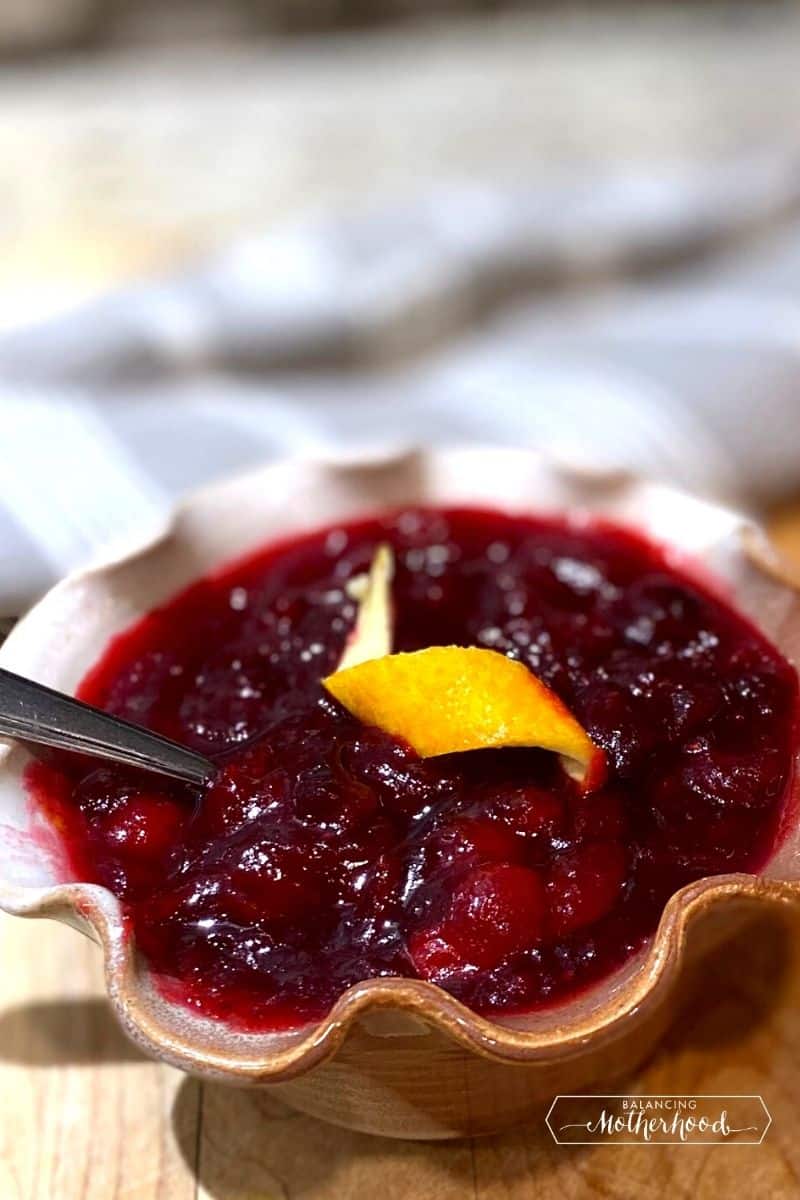 bowl of cranberry sauce with orange twist on top