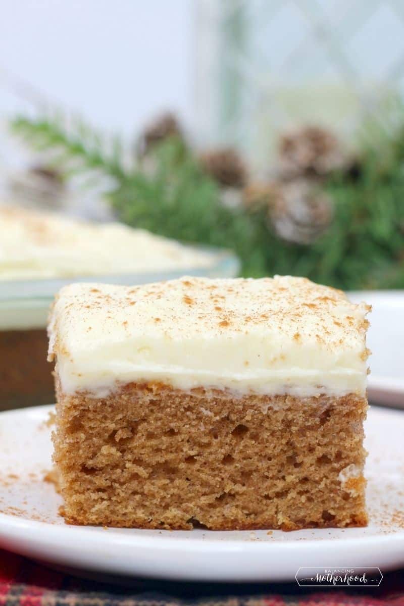 square piece of gingerbread sheet cake with cream cheese frosting on top