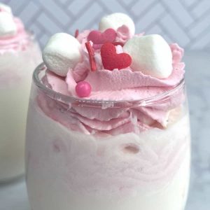 whipped strawberry cream on top of glass of milk