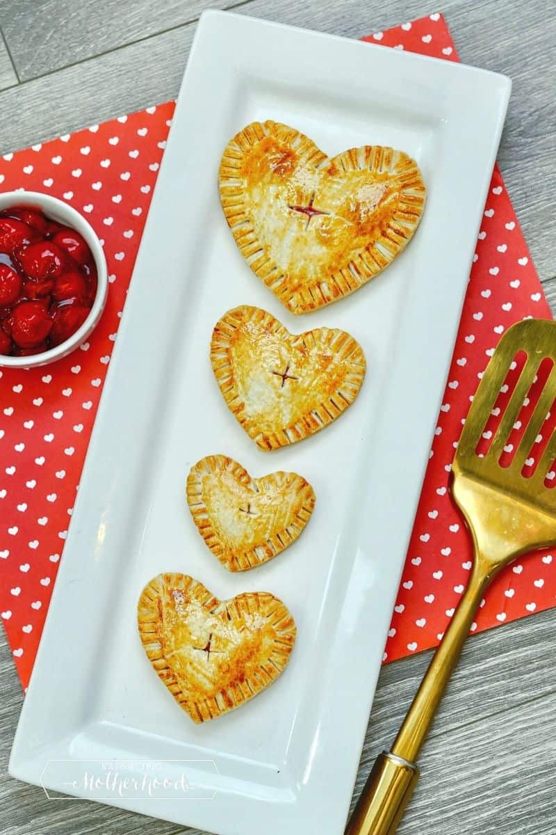 narrow white plate with four heart-shaped hand pies