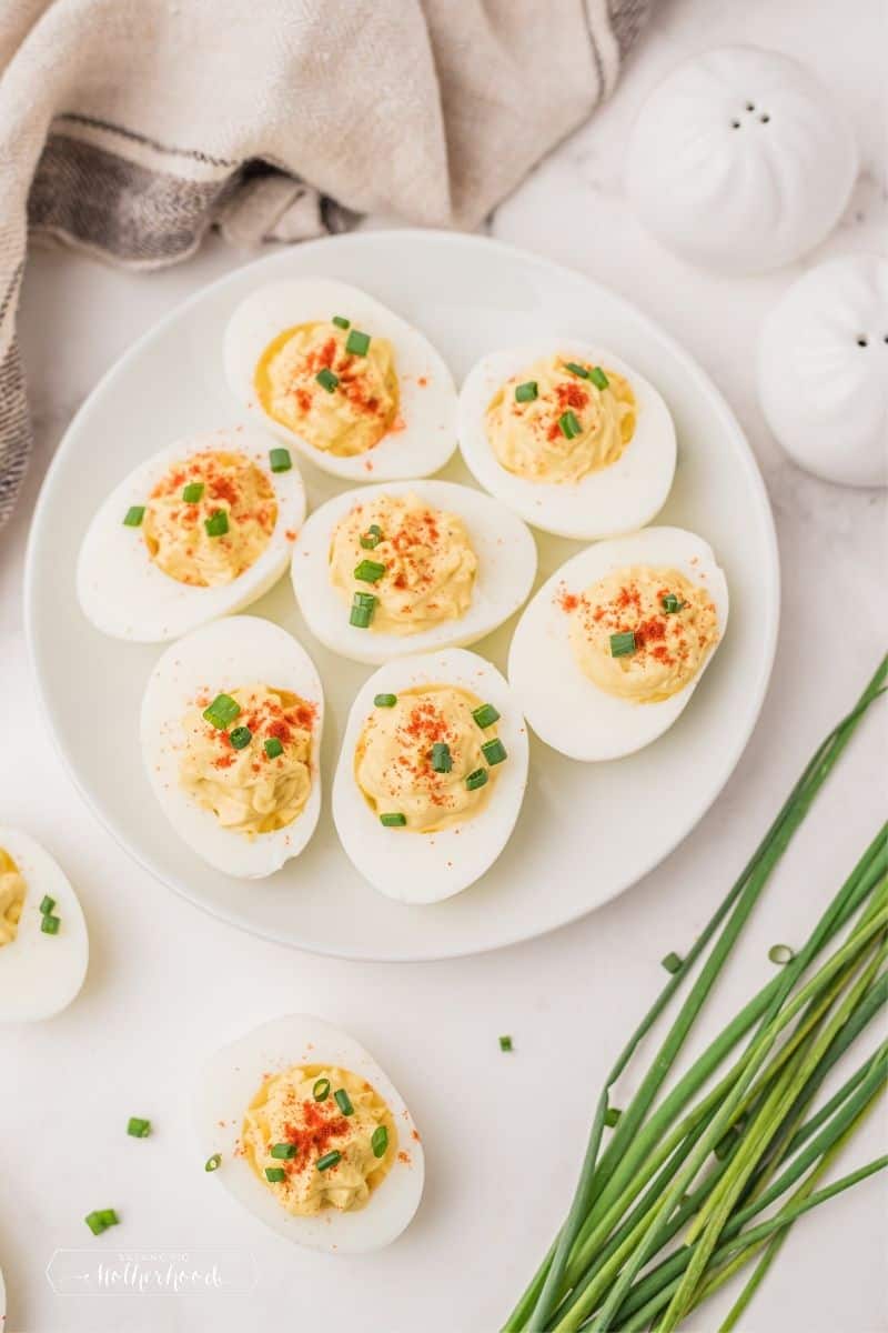 deviled eggs with paprika and chives on white counter