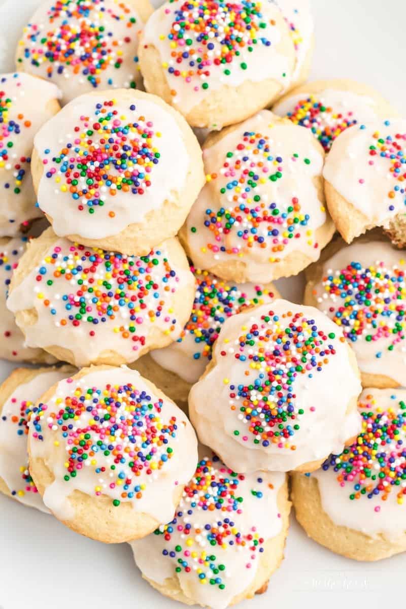 plate stacked with Italian ricotta cookies with colorful rainbow nonpareils