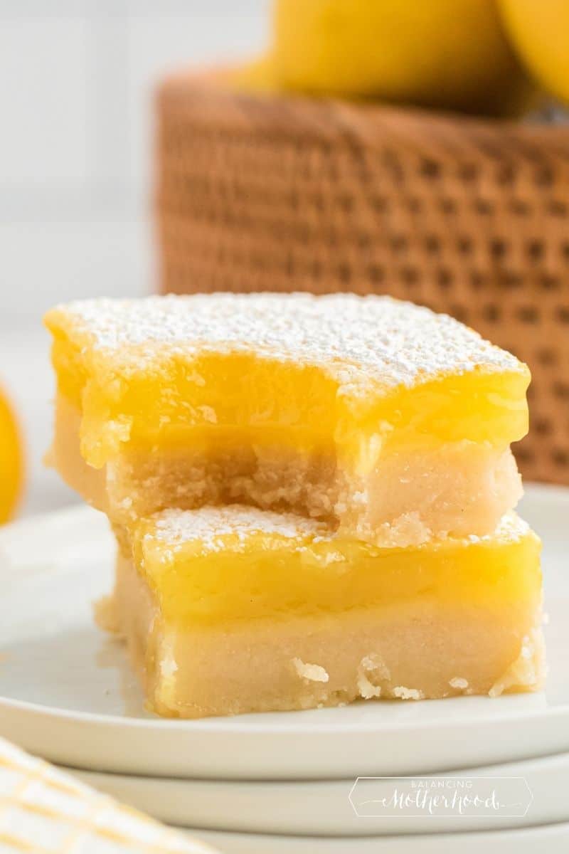 two lemon bars stacked, top one has bite out