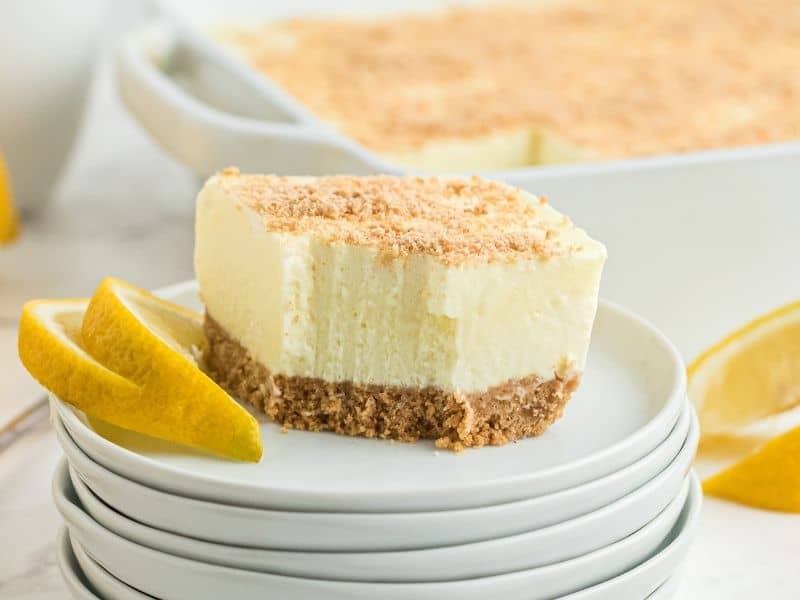slice of cheesecake with lemon slices on white plate