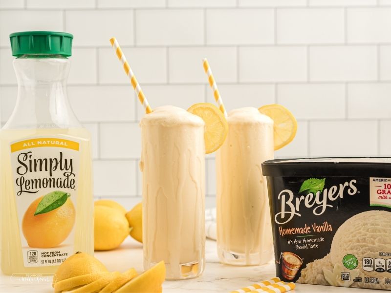 Simply Lemonade jar with two glasses of frosted lemonade with whipped cream, and Breyers ice cream