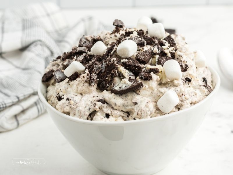 white bowl piled high with oreo fluff topped with crushed oreos and mini marshmallows