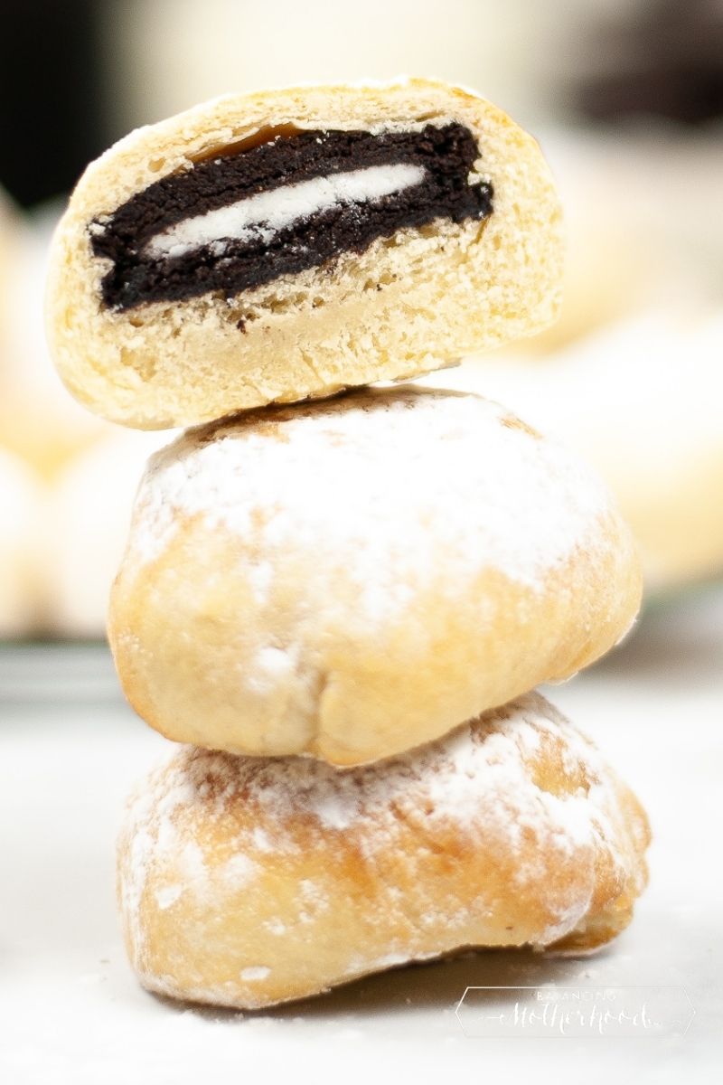 stacked air fried Oreos. Top one is cut in half showing the inside with an Oreo in the middle.