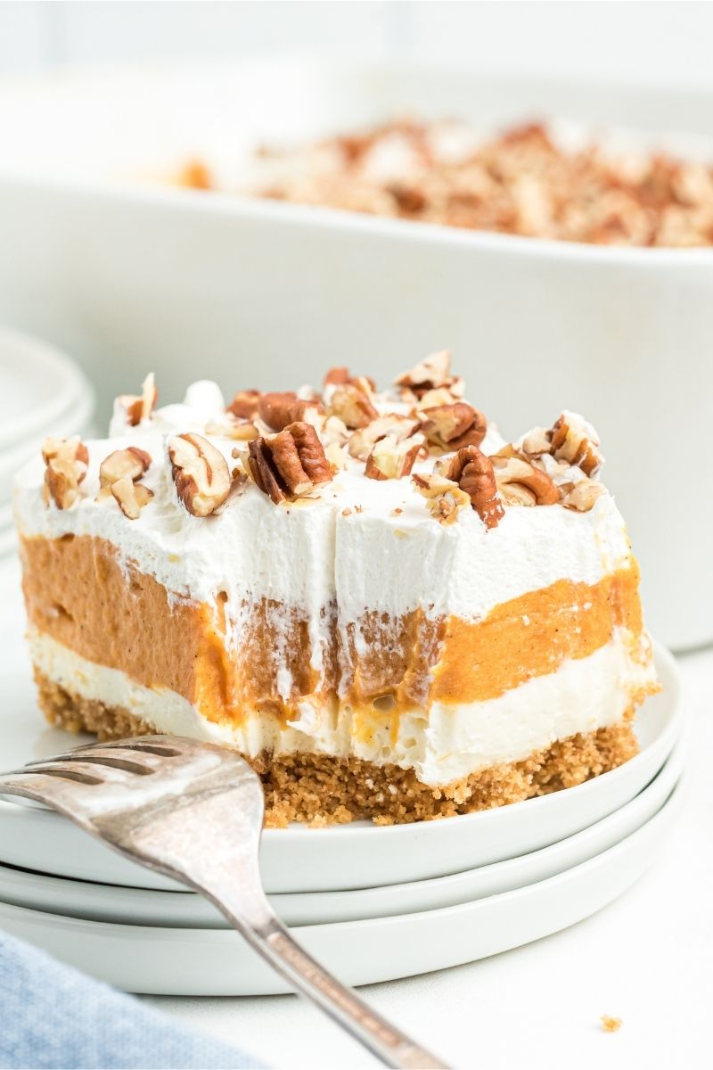 slice of layered pumpkin dessert with a bit out of it