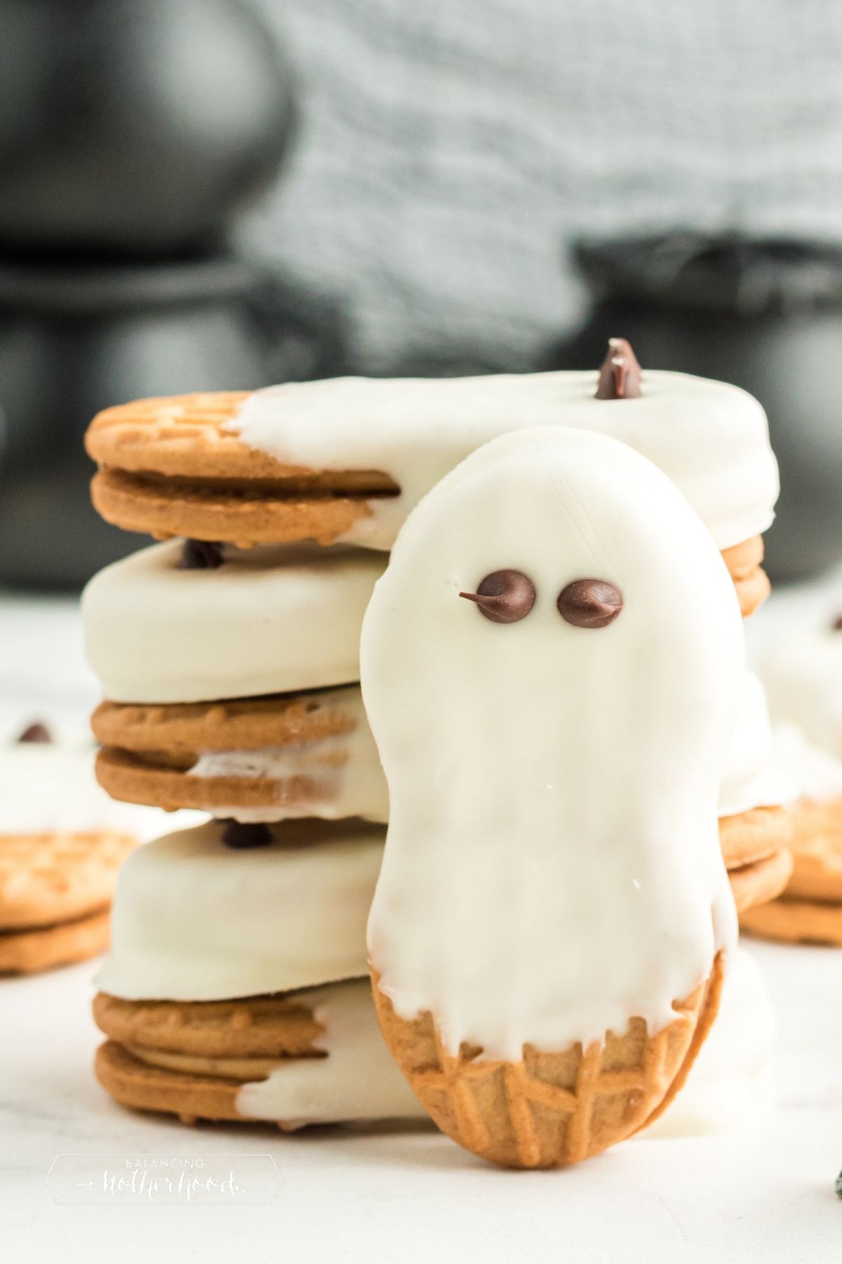 white chocolate covered Nutter Butter cookies stacked, one standing on end with chocolate eyes