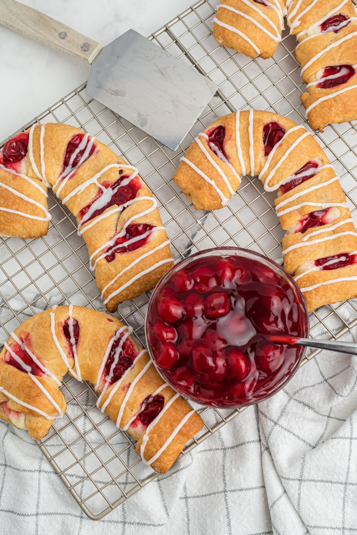 three danishes in the shape of candy canes with cherries