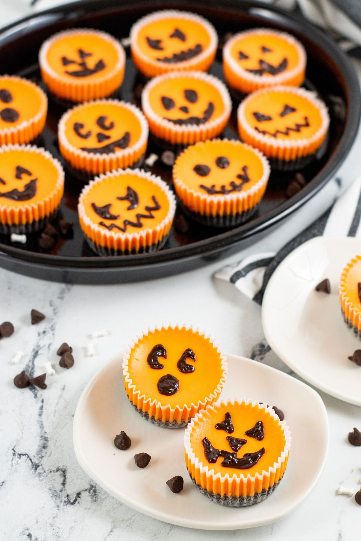 mini orange cheesecakes in cupcake liners with chocolate jack-o-lantern faces