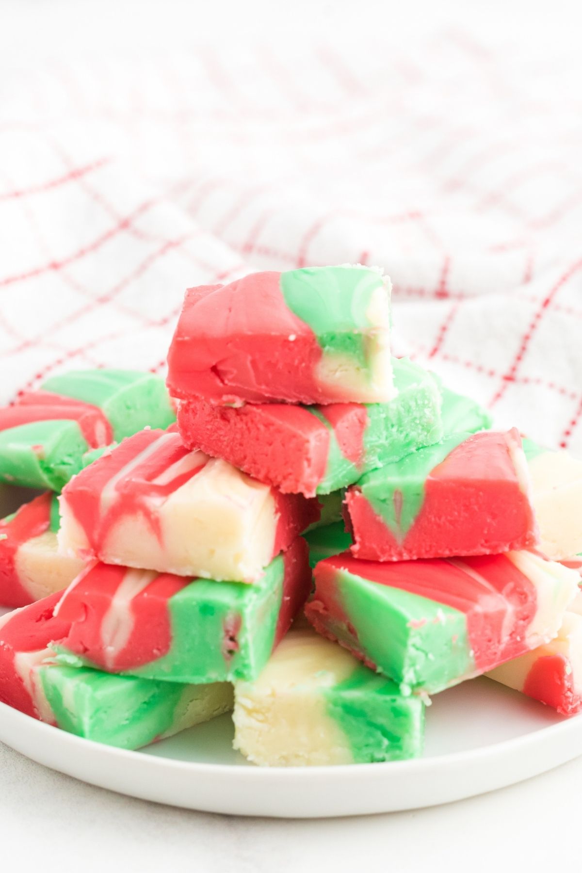 red, green and white fudge squares stacked on plate