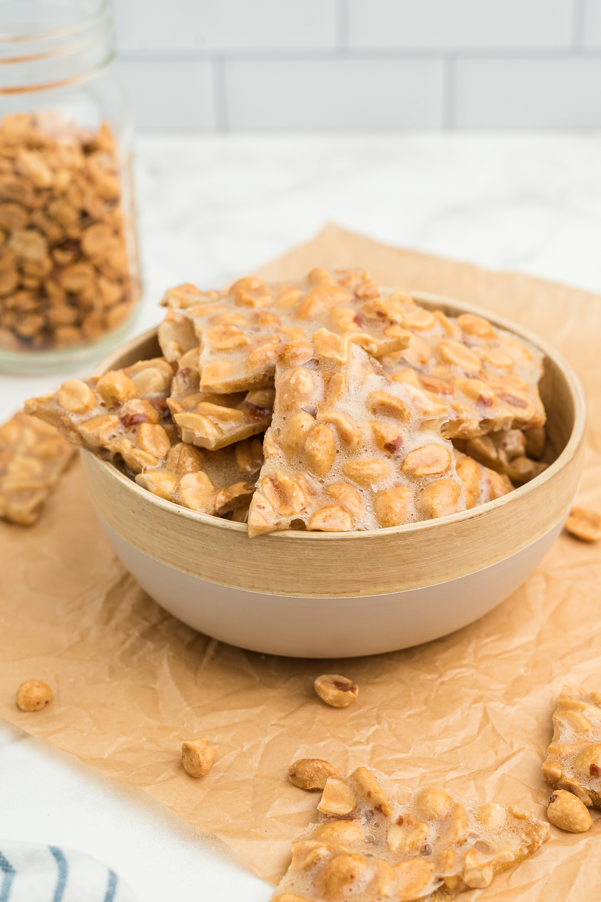 Microwave peanut brittle recipe on a bowl with a brown paper and on a counter