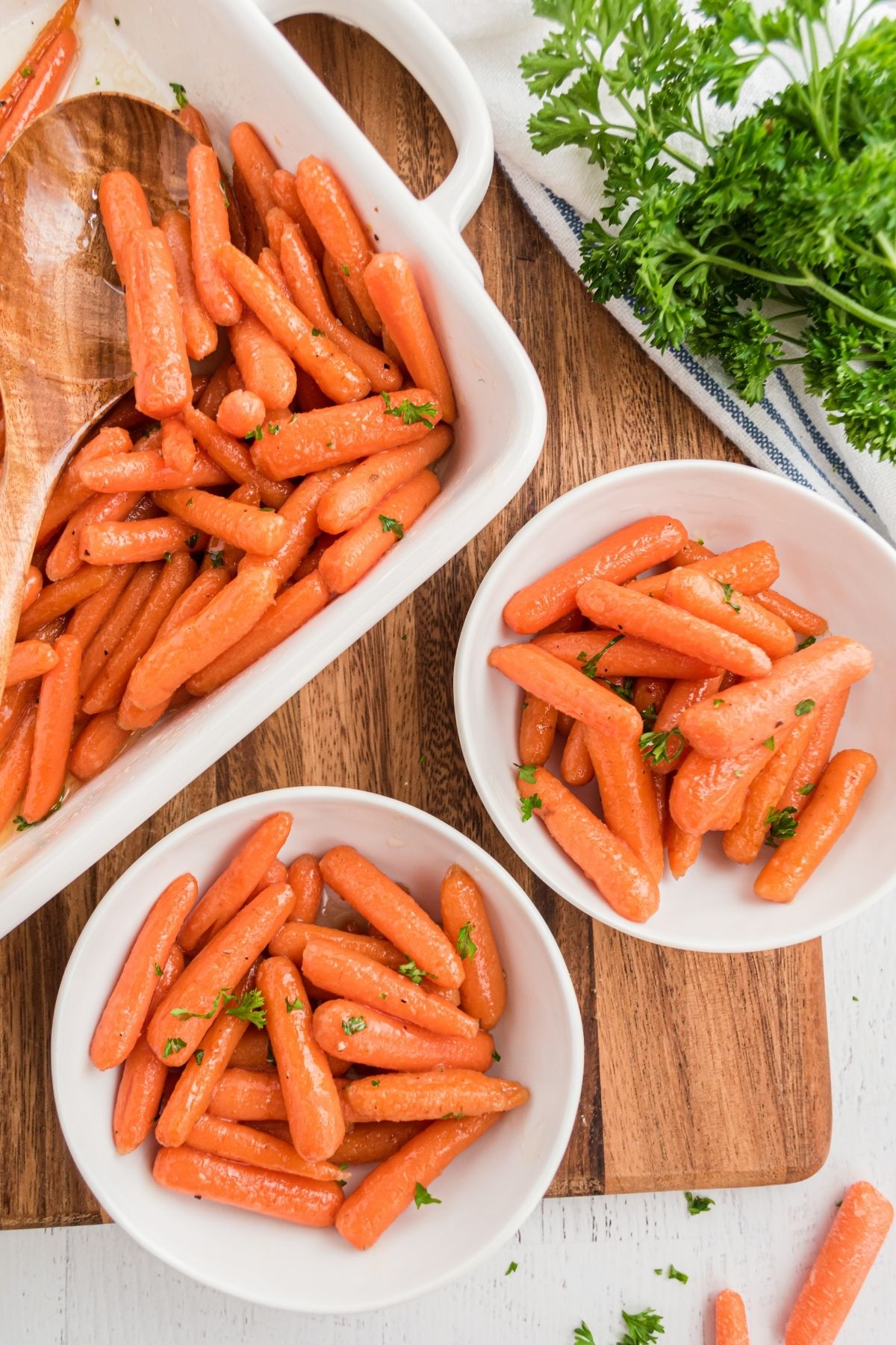 baked carrots in glaze in white bowls on cutting board