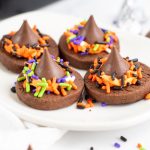 four chocolate cookies with Hershey kisses and sprinkles