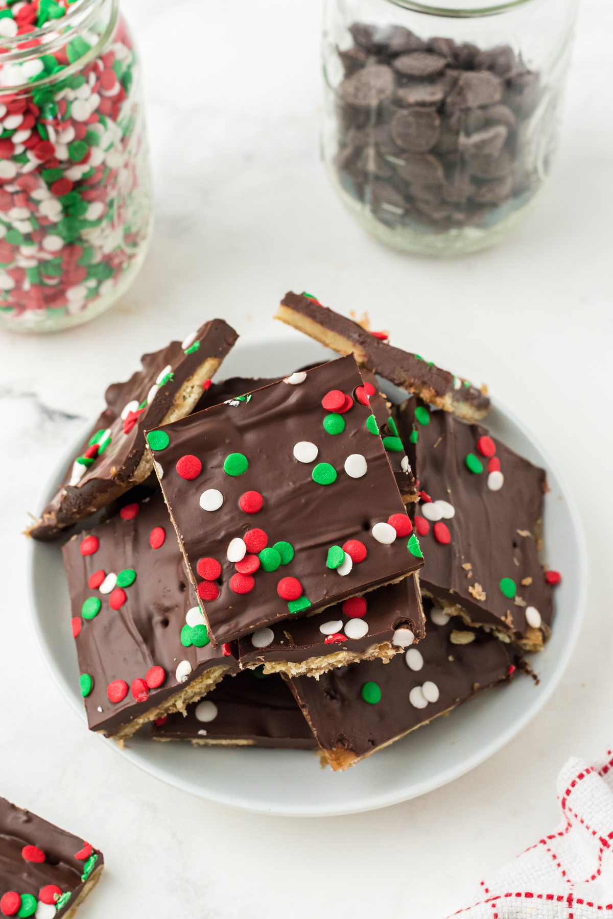Slices of Christmas crack recipe on a white dessert dish.