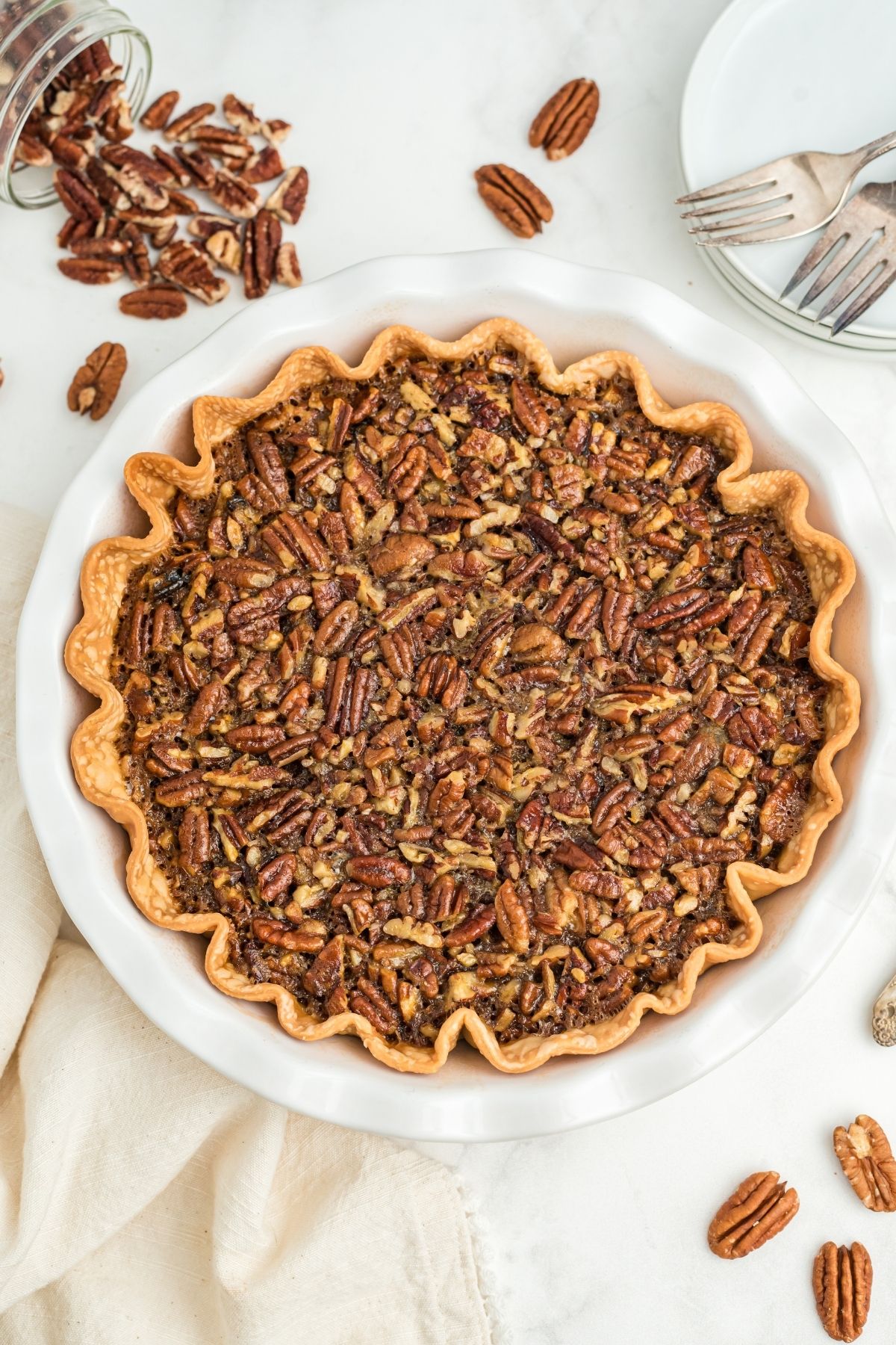 whole pecan pie with pecans on counter