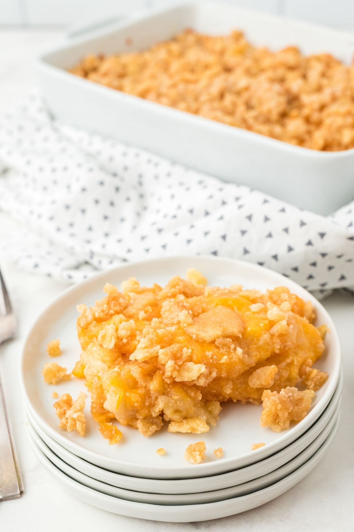 plate with orange pineapple casserole with crushed Ritz crackers on top