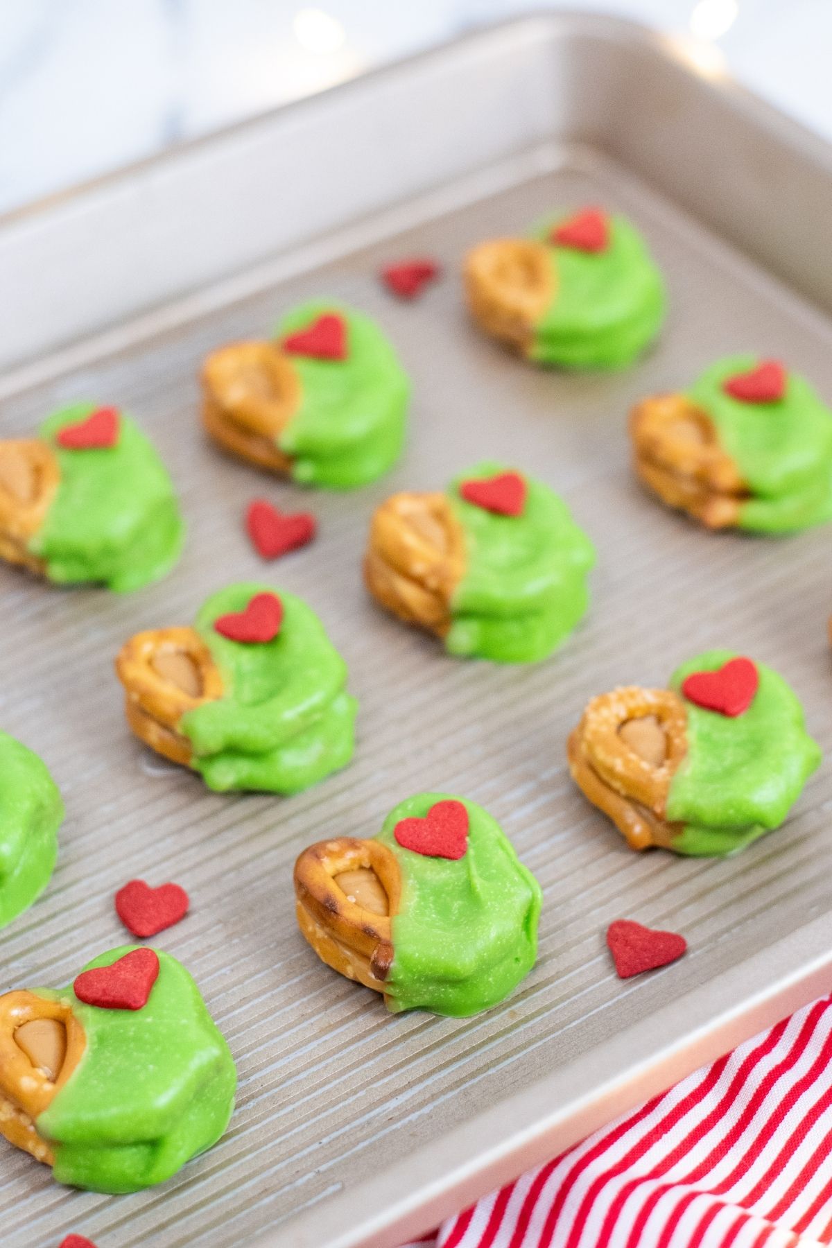 bright green coated pretzels with a large red heart lined on a baking tray