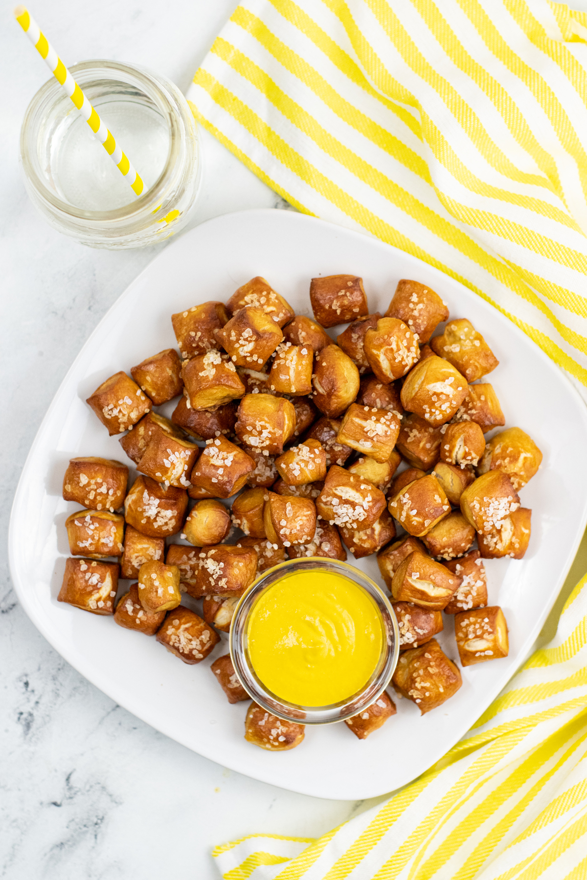 pretzel bites on white plate with a side of mustard sauce