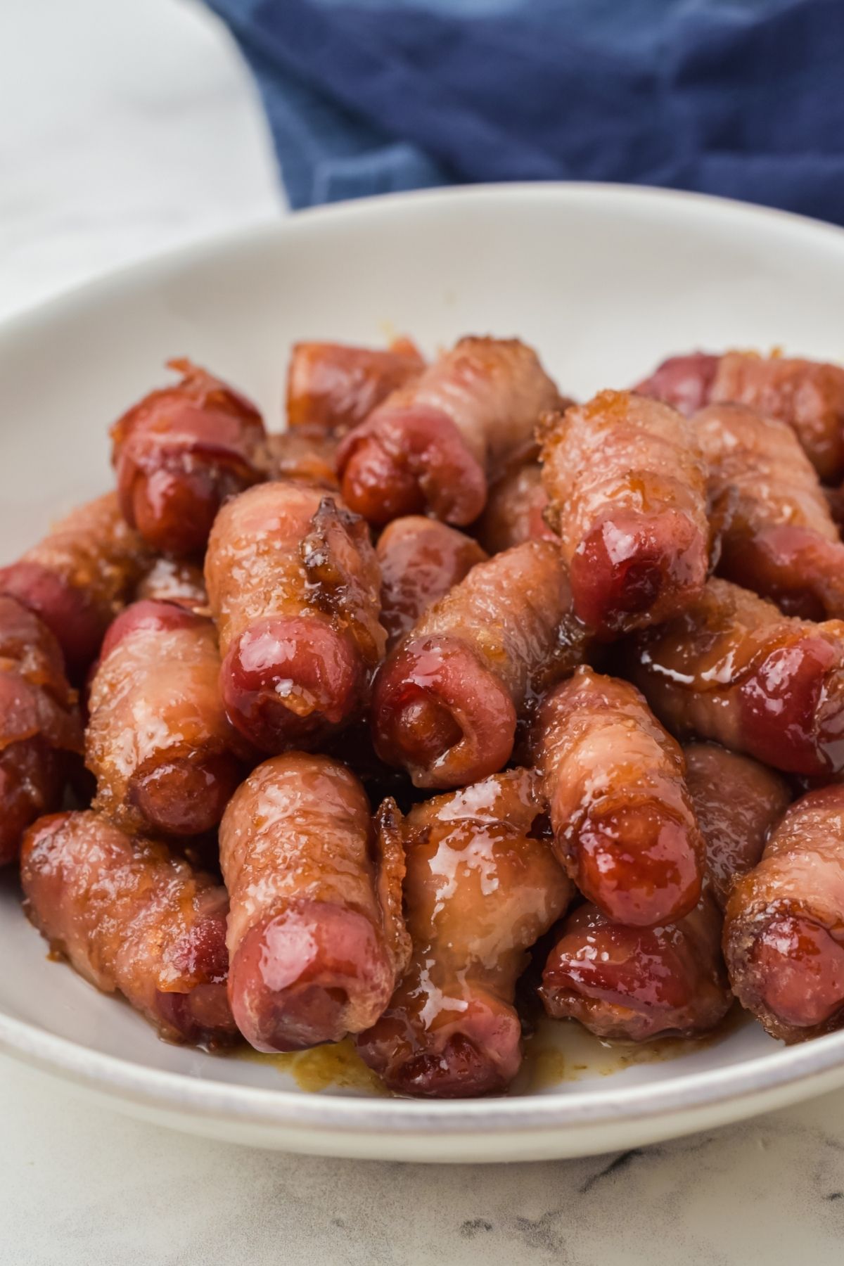 brown sugar melted on bacon wrapped smokies in white bowl