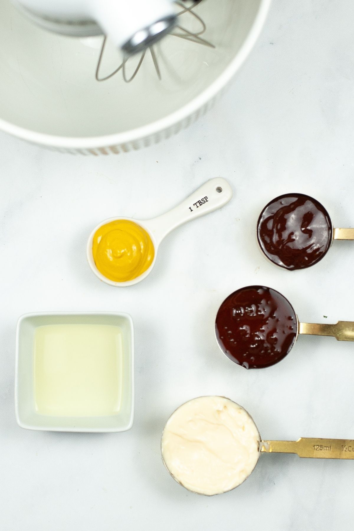 kitchen aid mixer with ingredients on counter: mustard, honey, BBQ sauce, mayonnaise