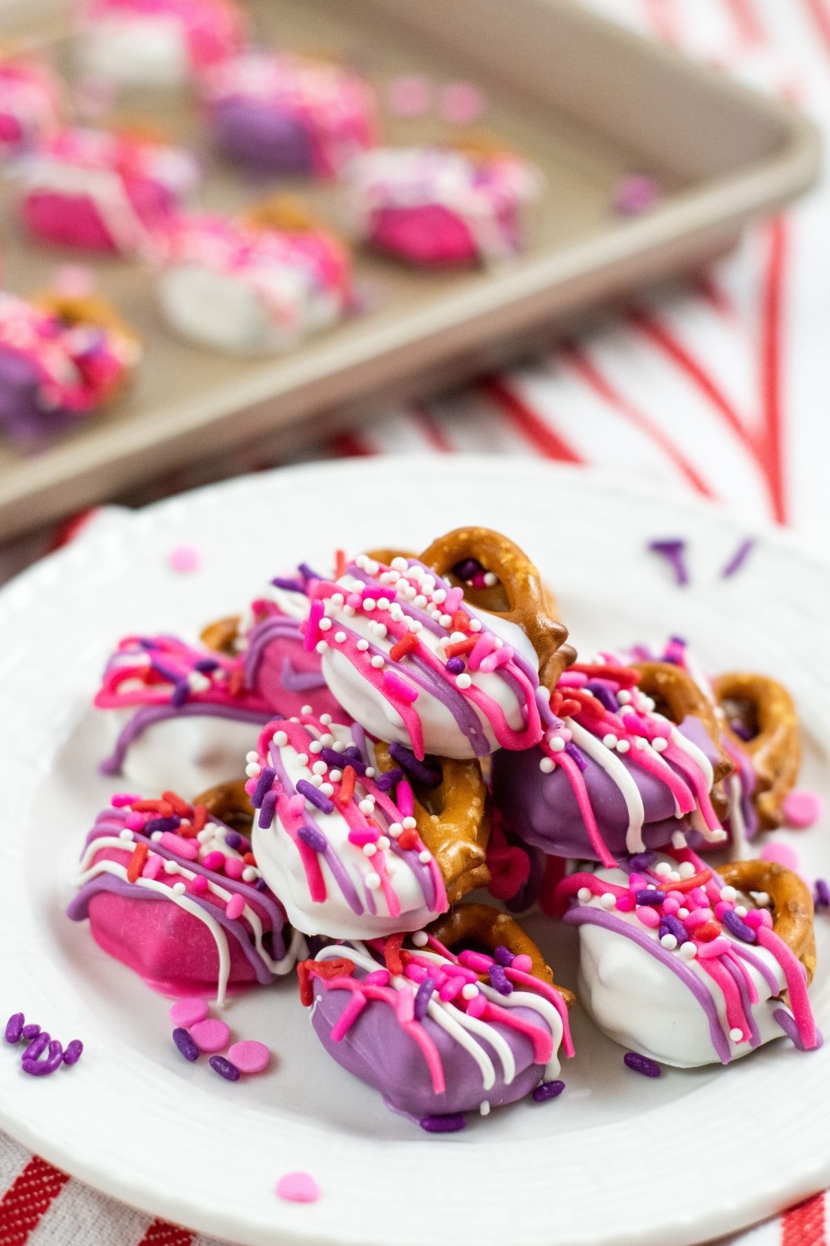 white plate stacked with pinke and purple pretzel bites