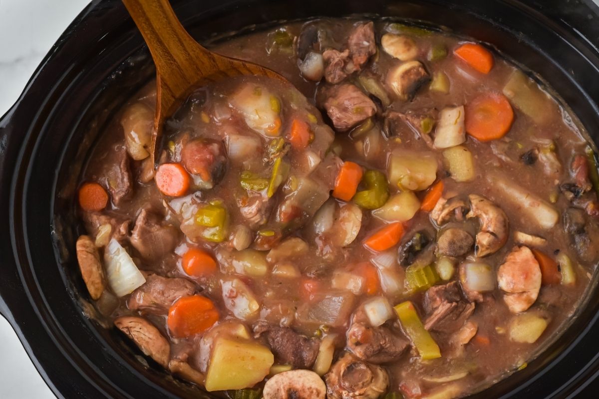 crockpot with wooden ladle full of beef stew