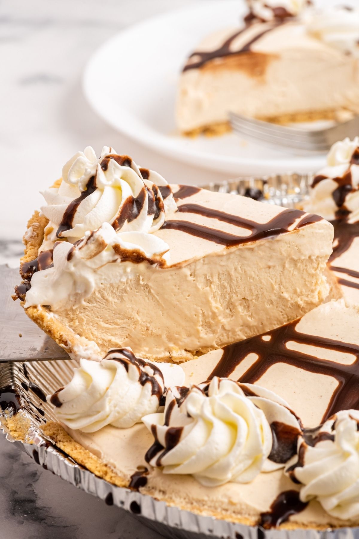 big slice of peanut butter pie on serving spoon showing the sides of the pie