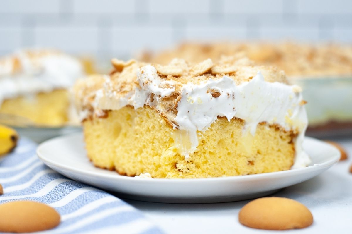 slice of yellow poke cake with whipped topping