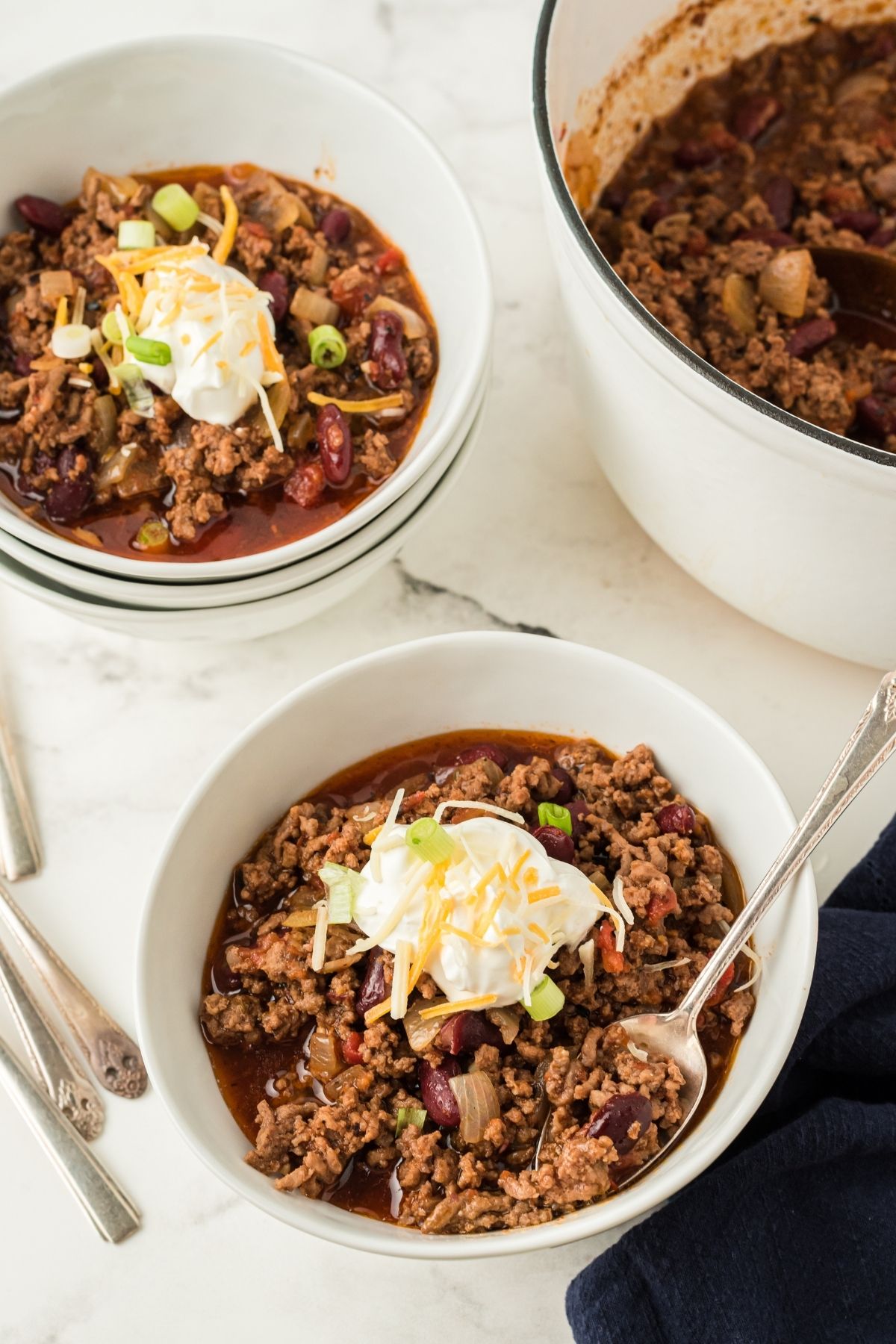two bowls with chili and sour cream on top