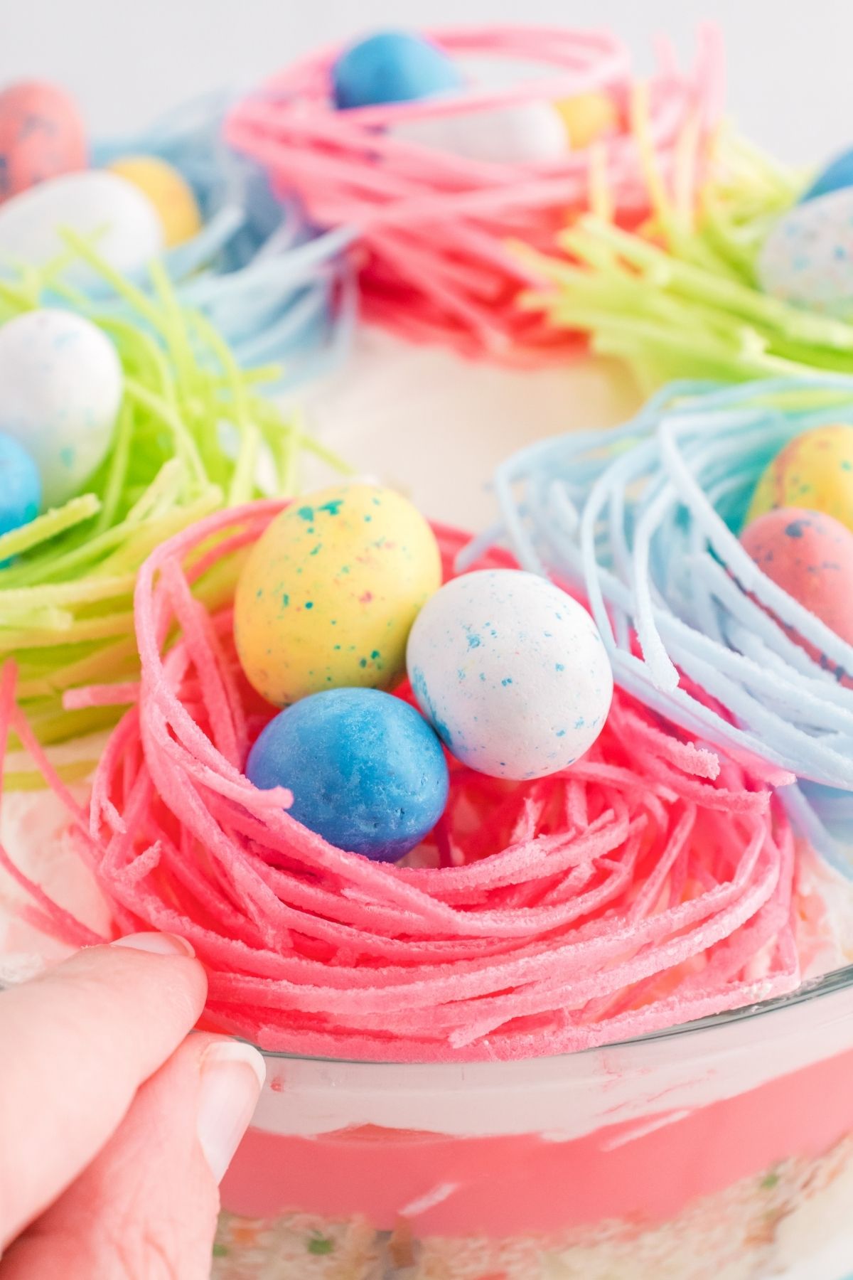 pink and blue bird's nests with candy Easter eggs on top of trifle