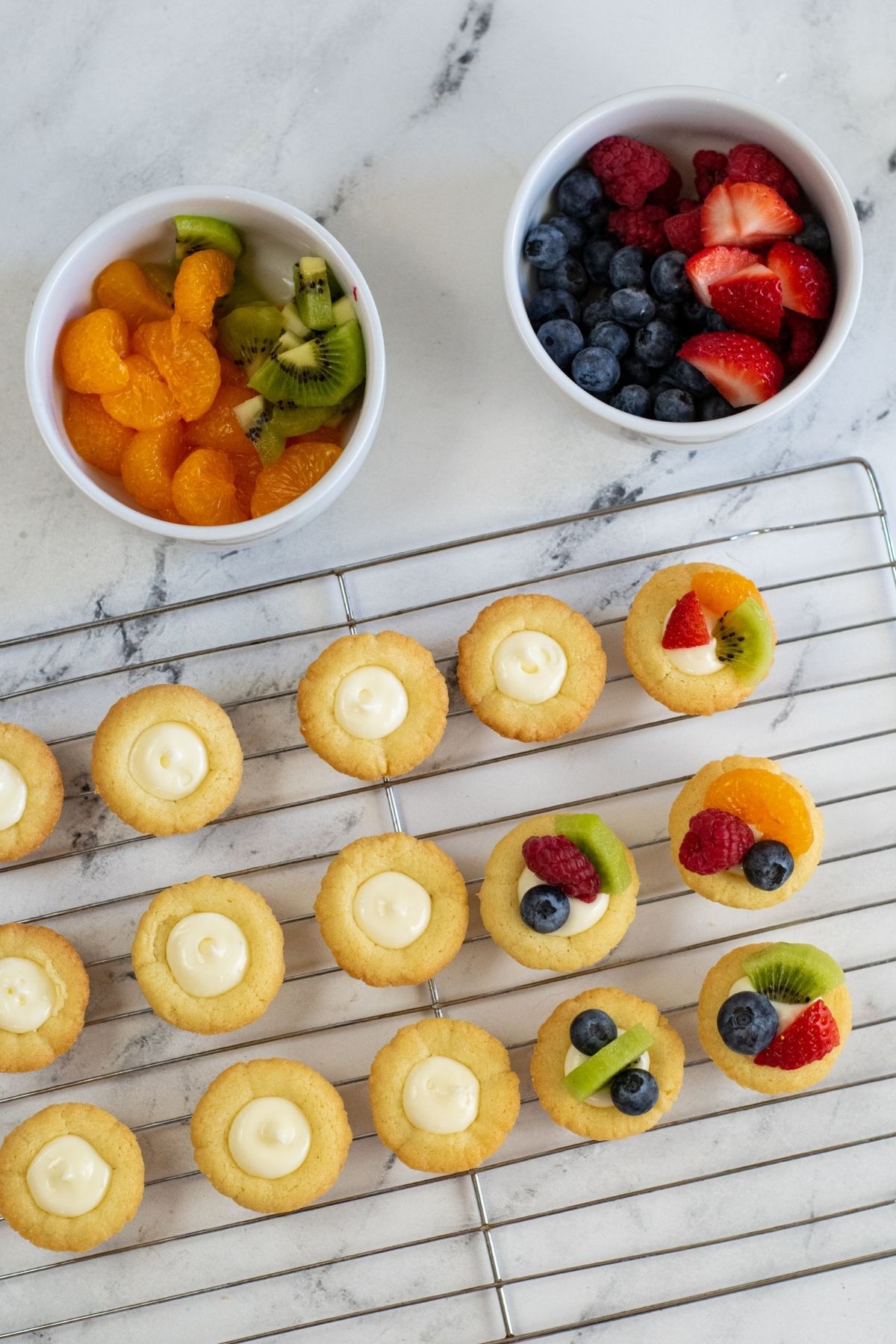 baked tarts with frosting and topping with fresh fruit