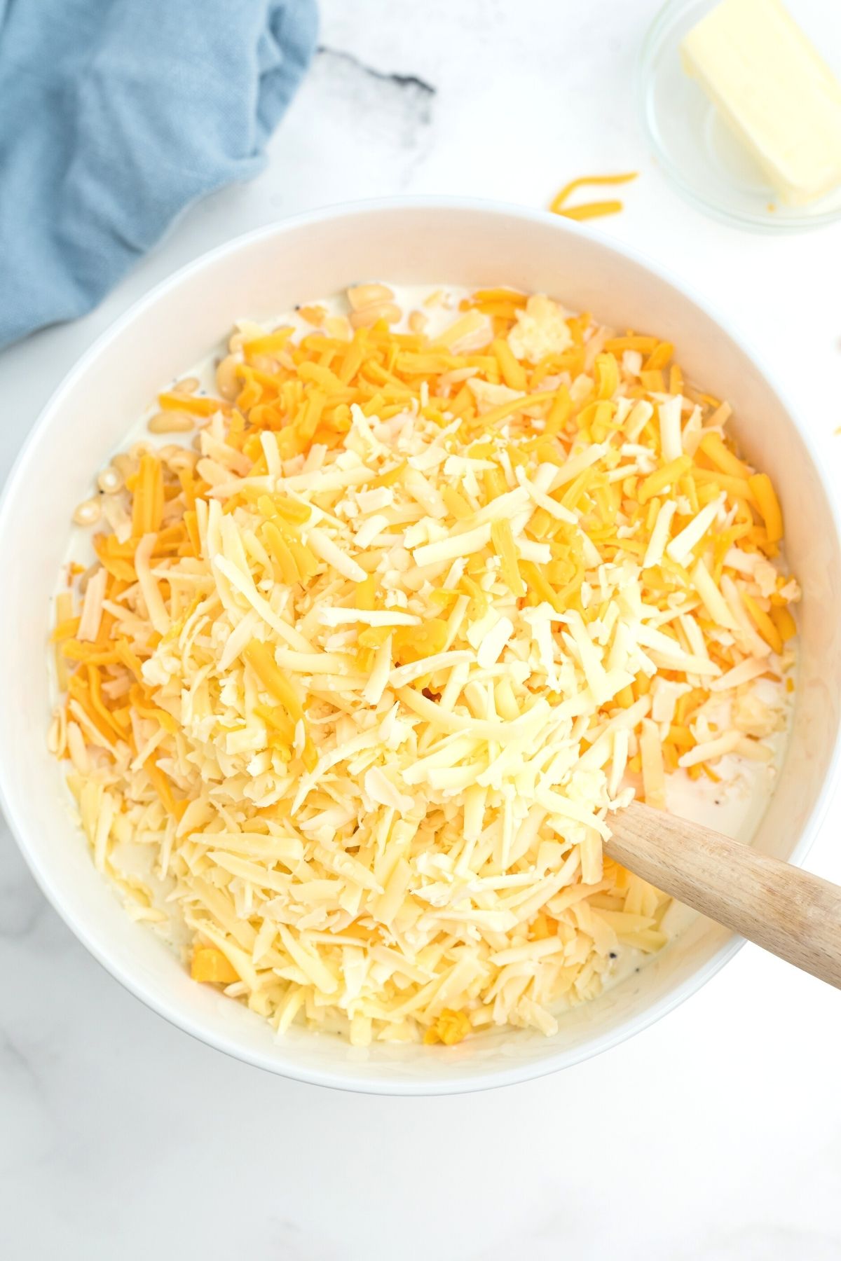 bowl with elbow macaroni and milk with shredded cheese on top